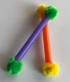closeup of cat toy, closeup of toys, looks like a solid colour straw with different colour pompoms on each end, 5" long