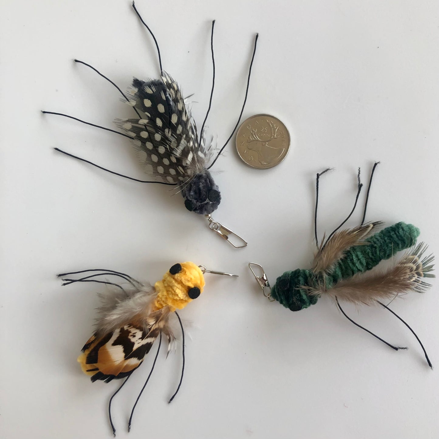 3 varieties of "bugs", made with velour velvet body, feather wings and string legs, cats can't resist. come in a variety of shapes and colours, shown here beside a coin for size reference