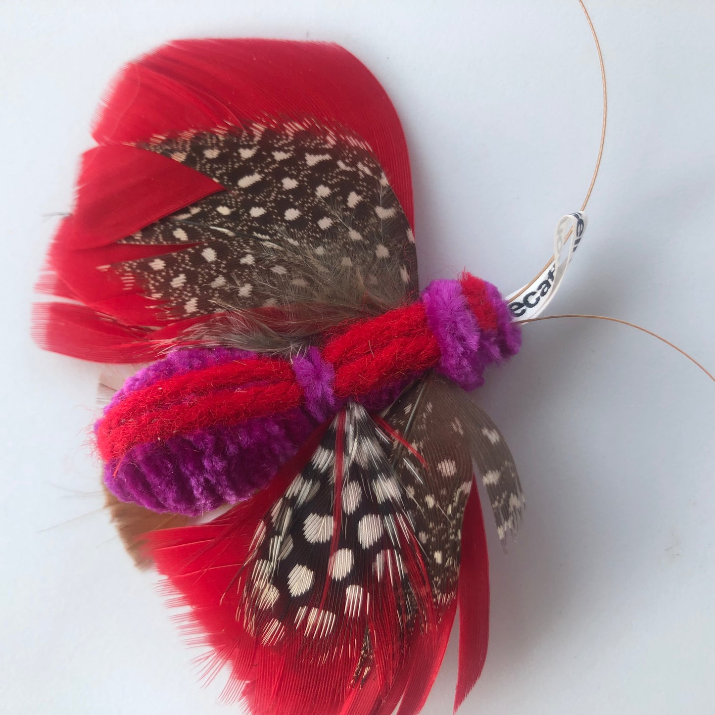 cat toy made with feathers that looks like a butterfly closeup