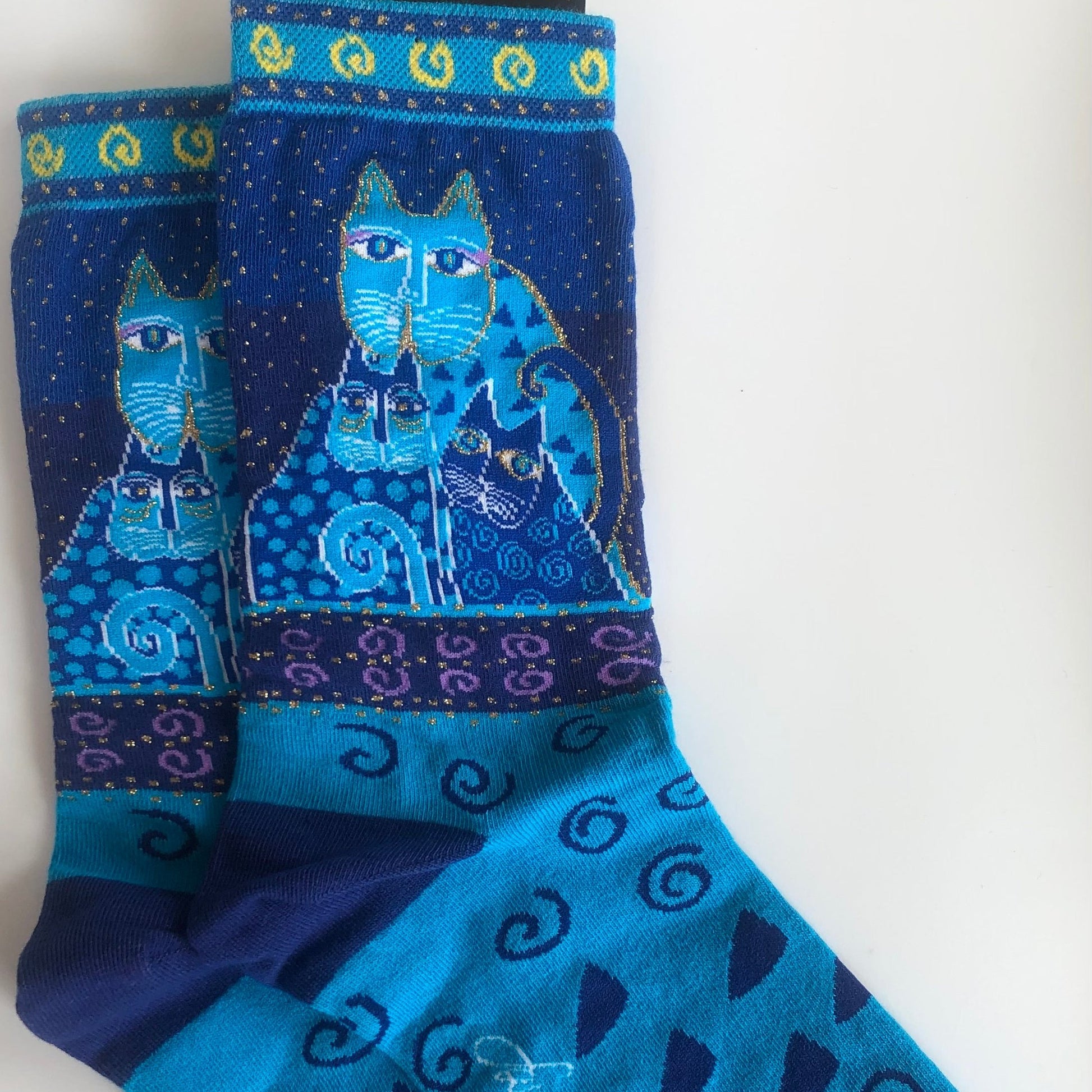 beautiful Laurel Burch crew socks with turquoise cat with 2 kittens and iconic gold swirls at cuff and blue geometrics on foot