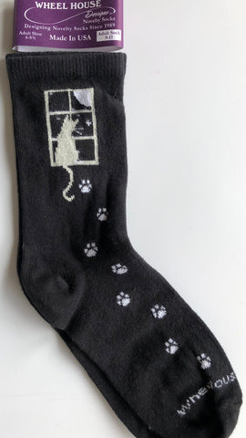 wheel house brand black crew sock with cat looking out the window at the moon, cute white paw prints all the way down to the toes