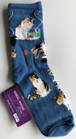 periwinkle blue crew sock with calico cats playing all over - chasing ball, fishing, siting beautiful with green eyes