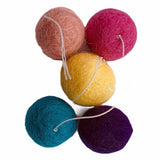 wool balls with thread "tail" are small enough for a cat to pick up with their mouth to carry or toss, just over an inch (2.5 cm) in diameter