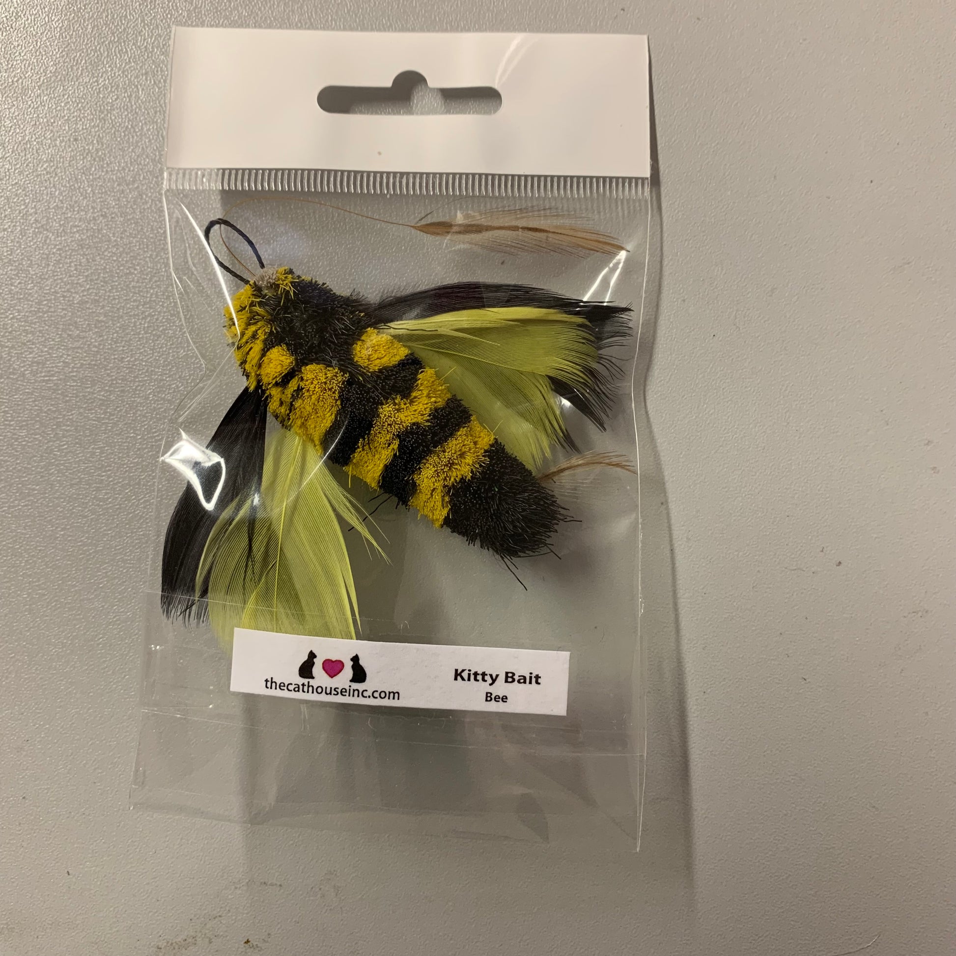 handmade cat toy attachment with black and yellow striped body and black and yellow feather wings